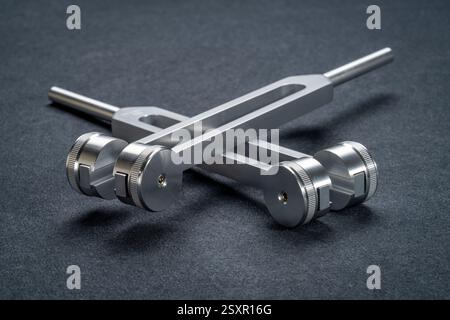 Gewichtete und ungewichtete Stimmgabeln aus Metall, die zum Abstimmen von Musikinstrumenten, zur Klangtherapie, zur Chakra-Heilung oder Entspannung verwendet werden. Stockfoto