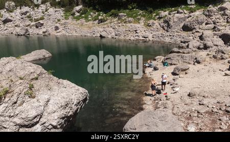 Triglav-Seen-Tal, Slowenien - 15. Juli 2024: Schwarzer See, im slowenischen Crno jezero, am sonnigen Nachmittag. Bergsee umgeben von Kiefern Stockfoto
