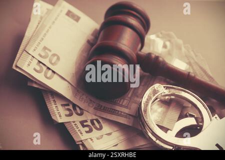 Hamel und vier Euro-Banknoten und Handschellen. Auktionsgebote, Korruptionskonzept des Justizsystems. Getönt Stockfoto