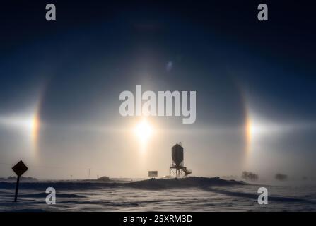Wunderschöne Sonnenhunde beleuchten eine kalte Winterlandschaft und schaffen ein atemberaubendes atmosphärisches Phänomen Stockfoto