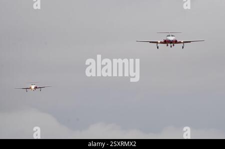 Zwei Trainingsflugzeuge fliegen bei bewölktem Himmel und führen einen synchronisierten Flug durch Stockfoto