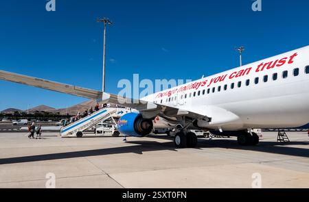 Das Flugzeug parkt auf dem Flughafenparkplatz mit Einstiegstreppen und Fluggäste, die unter klarem blauen Himmel Jet2 Lanzarote Airport ACE einsteigen Stockfoto