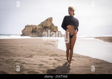Das wunderschöne venezolanische, blonde Bikinimodell genießt die Schönheit des Alboran Sea und genießt im Urlaub ein herrliches Strandglück. Stockfoto