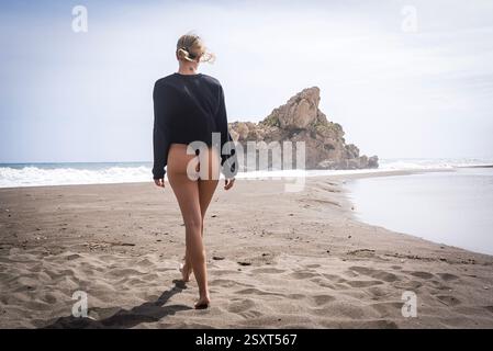 Das wunderschöne venezolanische, blonde Bikinimodell genießt die Schönheit des Alboran Sea und genießt im Urlaub ein herrliches Strandglück. Stockfoto