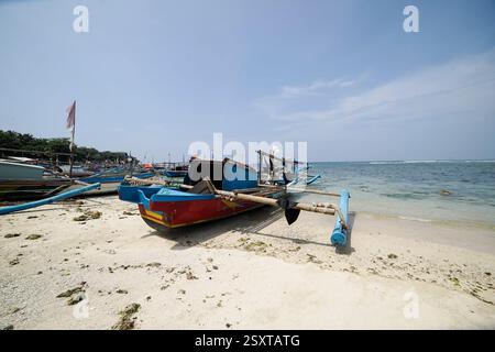 Das Fischerboot lehnt sich am schmutzigen weißen Sandstrand Stockfoto