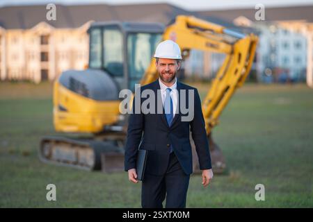 Buider-Mann in Anzug und Schutzhelm. Bauinvestor. Geschäftsmann-Investor vor der Baustelle. Erfolgreicher Investor. Ein hübscher Mann im Anzug Stockfoto