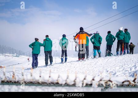 Gruppe von Menschen mit Lehrer dazwischen lernen Skifahren auf einer wunderschönen kleinen schneebedeckten Piste in Gulmarg Kaschmir, einem beliebten Resort und Touristen Stockfoto