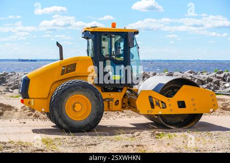 Schwingungseinzylinder-Laufrolle. Bodenverdichter zum Nivellieren von Boden für Fundamente und Straßenbau. Straßenverdichtungsausrüstung bei Co Stockfoto