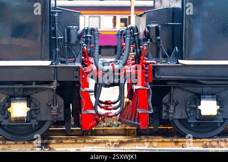 Kettenkupplung verbindet Güterwagen Retro-Dampflokomotiven nah, große Wagenpuffer sichtbar Stockfoto