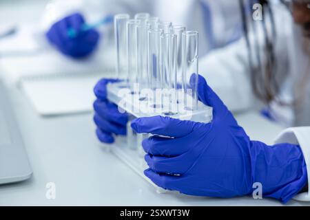 Nicht erkennbare Ärztin im Labor, die Pipetten hält, die Tests an Virusproben durchführen Stockfoto