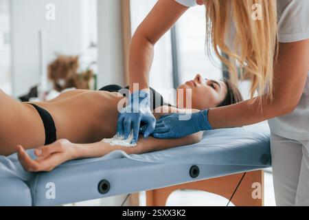 Frau wird in der Klinik von einer Ärztin mit Zucker behandelt. Stockfoto