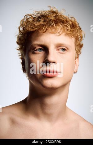 Ein junger Mann zeigt seine trendigen Locken und auffälligen Details und zieht mühelos Aufmerksamkeit auf sich. Stockfoto