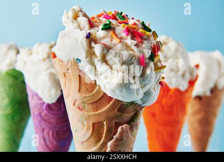 Vanilleeis mit Streuseln in verschiedenfarbigen Kegeln Stockfoto