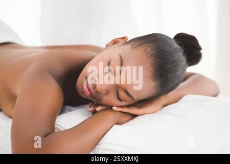 Entspannen Sie sich im Spa, eine ruhige Frau, die eine friedliche Massage auf einem weichen Handtuch genießt Stockfoto
