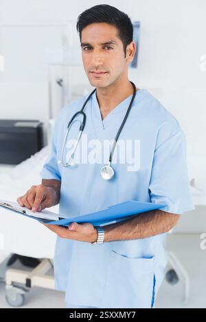 Im Krankenhaus, Arzt in Peelings, die Patientenakte mit Stethoskop überprüfen Stockfoto