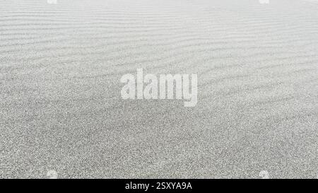 Strand Sand Hintergrund. Sand ist natürlich kühler gefärbt, pazifischer Strand in Peru. Wunderschönes Wellenmuster durch starken Wind. Stockfoto