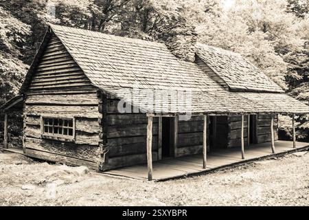 Blockhütte mit Veranda und schrägem Dach. Das Dach besteht aus Holzschindeln Stockfoto