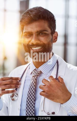 Porträt eines lächelnden männlichen Arztes, der in einem Krankenhausgang steht Stockfoto