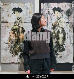 London, Großbritannien. Februar 2025. Mitarbeiter der Galerie Sklo posieren mit der „A Series of 21st-Century versions of Portraits of a Beauty (Scroll)-11“ des koreanischen Künstlers CHOI Hyesook, 2025. Collect feiert in diesem Jahr 21 Jahre als führende internationale Kunstmesse für zeitgenössisches Handwerk und Design. Collect 2025 wird vom Crafts Council präsentiert und läuft vom 28. Februar bis 2. März 2025 im Somerset House. Quelle: Imageplotter/Alamy Live News Stockfoto