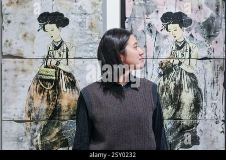 London, Großbritannien. Februar 2025. Mitarbeiter der Galerie Sklo posieren mit der „A Series of 21st-Century versions of Portraits of a Beauty (Scroll)-11“ des koreanischen Künstlers CHOI Hyesook, 2025. Collect feiert in diesem Jahr 21 Jahre als führende internationale Kunstmesse für zeitgenössisches Handwerk und Design. Collect 2025 wird vom Crafts Council präsentiert und läuft vom 28. Februar bis 2. März 2025 im Somerset House. Quelle: Imageplotter/Alamy Live News Stockfoto