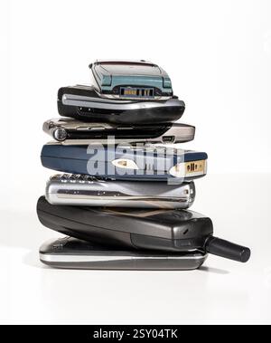 Isolierter Stack alter Handys, der die rasante technologische Entwicklung repräsentiert Stockfoto