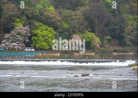 Touristen an der Togetsu-kyo-Brücke, einer Holzbrücke, die den Katsura-Fluss vor den Arashiyama-Bergen in Kyoto, Japan überspannt. Stockfoto