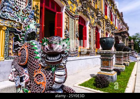 Die Skulptur eines Drachen vor der reich verzierten Fassade des Palastes Kien Trung, Điện Kiến Trung, Teil der Zitadelle Hue, Hoàng thành. Stockfoto