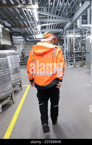 Hamburg, Deutschland. Februar 2025. Ein Mitarbeiter geht durch die Produktionsstätte der Holsten Brauerei im Hamburger Stadtteil Hausbruch. Quelle: Christian Charisius/dpa/Alamy Live News Stockfoto