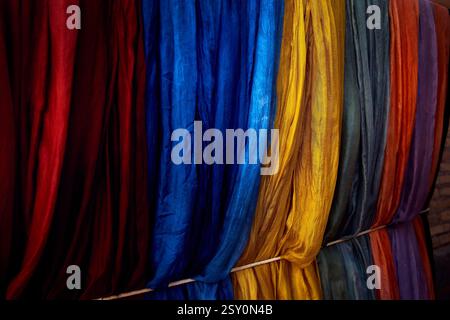 Farbenfrohe gelbe blaue und rote usbekische traditionelle Seidenschals auf dem lokalen Kunsthandwerksbazar in der Altstadt von Chiwa in Usbekistan Stockfoto