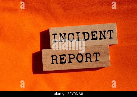 Meldung über den Vorfall auf Holzblöcken auf orangem Hintergrund. Symbol für den konzeptionellen Vorfallbericht. Kopierbereich. Stockfoto