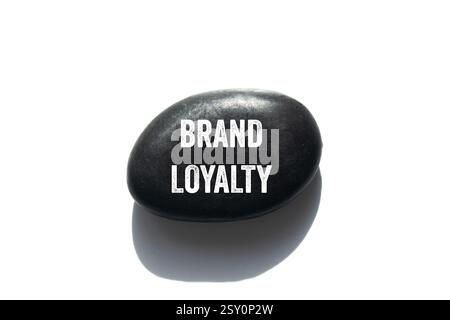 Markenbotschaft auf schwarzem Stein auf weißem Hintergrund. Konzeptionelles Symbol für Markenloyalität. Kopierbereich. Stockfoto
