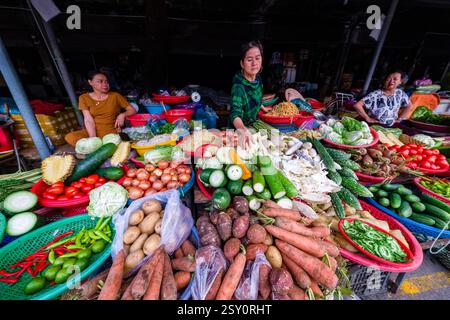 Eine Frau verkauft Gemüse und Obst auf einem der vielen Straßenmärkte im Zentrum von Hue. Stockfoto