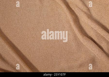 Textur aus goldbraunem Stoff. Abstrakter Hintergrund Stockfoto