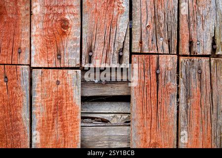 Aus nächster Nähe sehen verwitterte Holzdielen mit reichen Texturen und Farben, die einen rustikalen Charme in einer ruhigen ländlichen Lage vermitteln. Stockfoto
