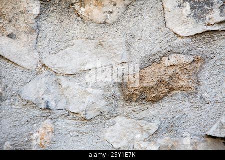 Eine detaillierte Nahaufnahme einer strukturierten Steinmauer mit zahlreichen Felsen Stockfoto