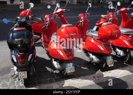 Red Scooter in Street, Vespa Rome, Italien - 9. Juni 2017: Eine Reihe roter Vespa-Scooter parkt entlang der Via Cavour, wo Sie einen Roller mieten. Rom RM Italien Copyright: XGennaroxLeonardix Stockfoto