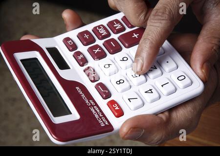 Mann, der Berechnungen auf dem Rechner MR#743AD macht Stockfoto