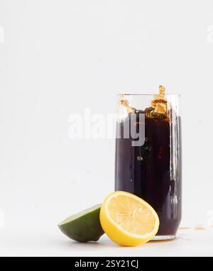 Dunkles Getränk, das in 100 % natürlichem Licht spritzt. Stockfoto