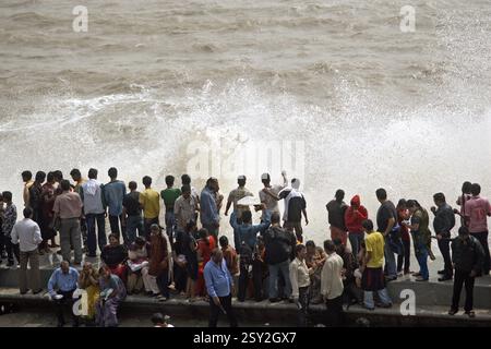 Menschen, die Hochwasserwellen genießen, am Marine Drive Bombay, Mumbai, Maharashtra, India NOMR Stockfoto