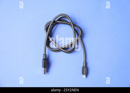 Ein USB-Ladekabel auf blauem Hintergrund, Draufsicht Stockfoto