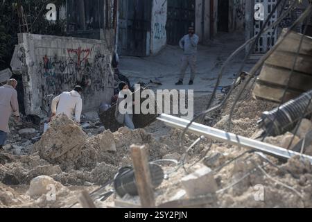 Tulkarm, Palästina. Februar 2025. Palästinensische Familien tragen ihre Sachen, als sie aus dem Flüchtlingslager Nour Shams fliehen. Israelische Truppen erlaubten den Bewohnern, ihre Sachen zurückzuholen, nachdem sie Abrissanzeigen für mehrere Häuser ausgestellt hatten, während eines wochenlangen Angriffs auf das Westjordanland, bei dem rund 30.000 Palästinenser aus ihren Häusern innerhalb des nur Shams Flüchtlingslagers vertrieben wurden. Quelle: SOPA Images Limited/Alamy Live News Stockfoto
