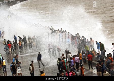 Menschen, die Hochwasserwellen genießen, am Marine Drive Bombay, Mumbai, Maharashtra, India NOMR Stockfoto