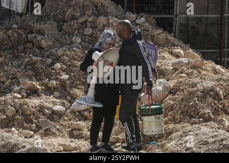 Tulkarm, Palästina. Februar 2025. Palästinensische Familien tragen ihre Sachen, als sie aus dem Flüchtlingslager Nour Shams fliehen. Israelische Truppen erlaubten den Bewohnern, ihre Sachen zurückzuholen, nachdem sie Abrissanzeigen für mehrere Häuser ausgestellt hatten, während eines wochenlangen Angriffs auf das Westjordanland, bei dem rund 30.000 Palästinenser aus ihren Häusern innerhalb des nur Shams Flüchtlingslagers vertrieben wurden. Quelle: SOPA Images Limited/Alamy Live News Stockfoto