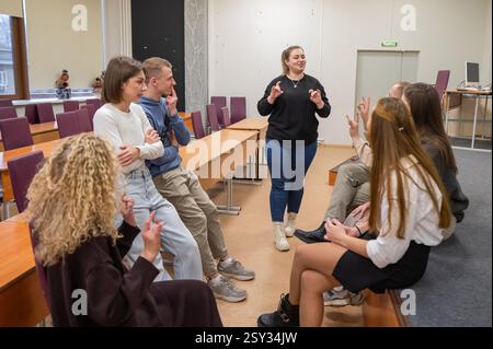 Junge Menschen kommunizieren in Gebärdensprache in einem Universitätsklassenzimmer. Stockfoto