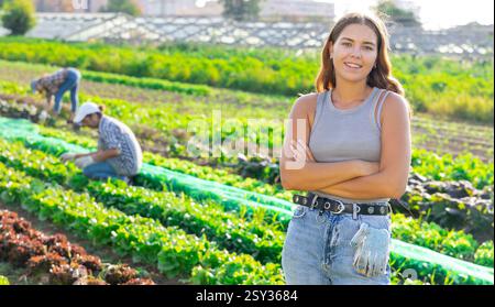 Porträt junger glücklicher Hofbesitzer vor dem Hintergrund des Feldes mit Gemüseernte Stockfoto