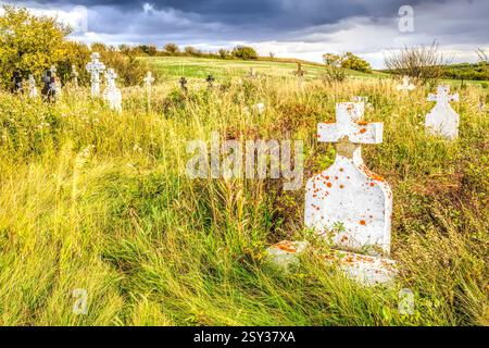 Friedhof mit vielen weißen Grabsteinen und einem Kreuz. Das Kreuz befindet sich in der Mitte des Feldes Stockfoto
