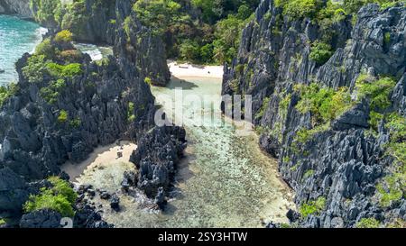 Der versteckte Strand von Matinloc Island, El Nido: Aus der Vogelperspektive auf eine abgelegene Bucht, zerklüftete Klippen und klares türkisfarbenes Wasser. Tropisches Paradies, geheimes Refugium. Stockfoto