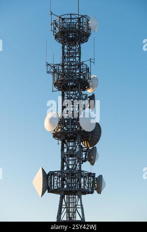 Nahaufnahme Telekommunikationsturm mit Satellitenschüsseln auf blauem Himmel Hintergrund Stockfoto