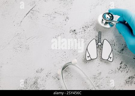 Arzt Hand in Handschuhen prüft Lunge Papier mit einem Stethoskop zum Welt-TB-Tag. Verbreitung des Bewusstseins über die Gesundheit der Lunge, Tuberkulose und Atemwege Stockfoto