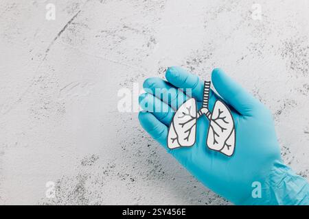 World TB Day-Konzept mit Arzthandschuhen in der Hand, die Lungenpapier halten. Hervorhebung der Lunge Gesundheit, Tuberkulose Bewusstsein, und Atemwegserkrankungen wie Stockfoto